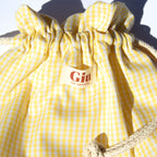 Détail du tissu vichy jaune en coton de la pochette Giu, doux et léger pour un usage quotidien