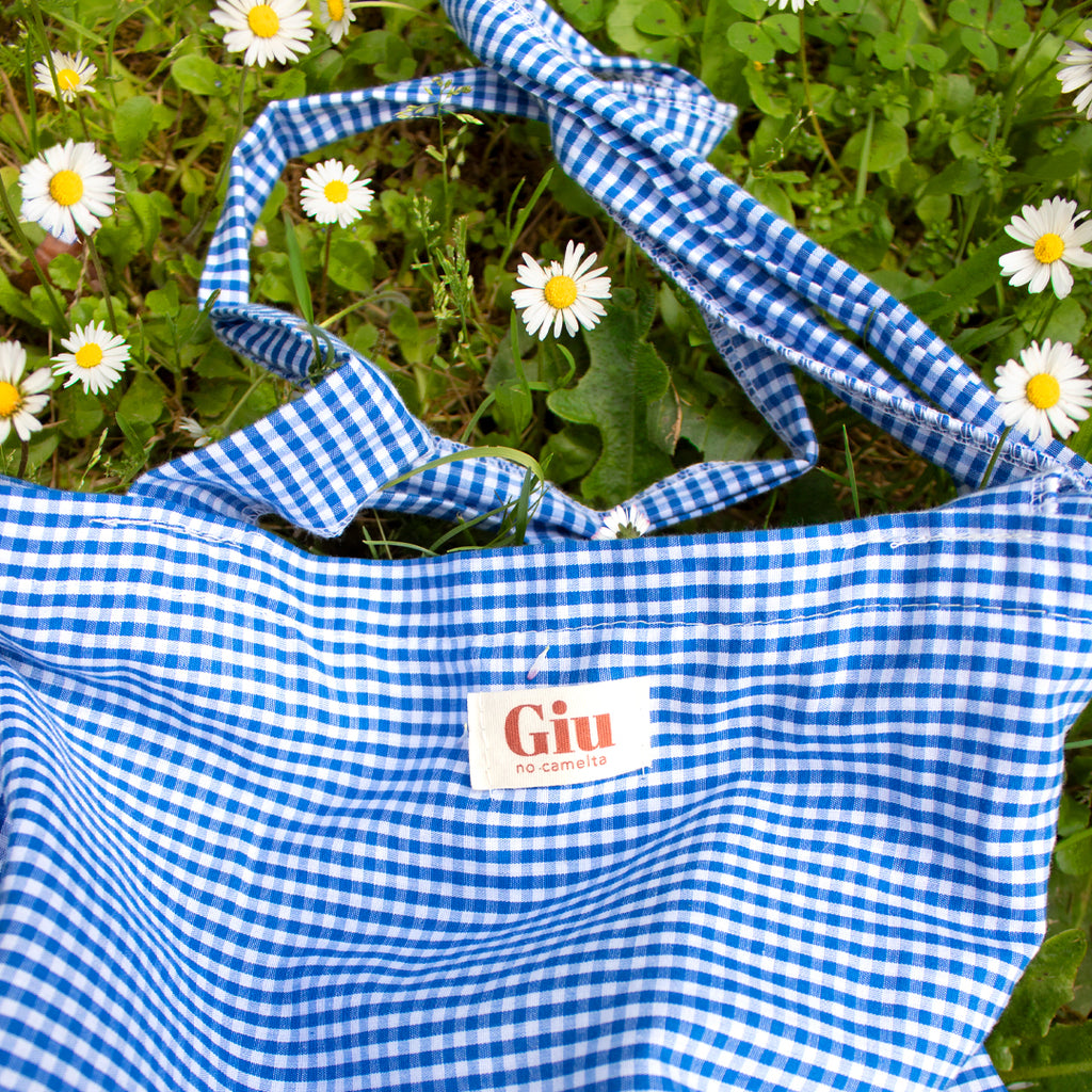 Tote bag vichy bleu Giu posé dans l'herbe, ambiance été artisanal