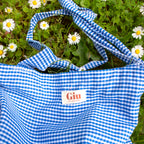 Tote bag vichy bleu Giu posé dans l'herbe, ambiance été artisanal